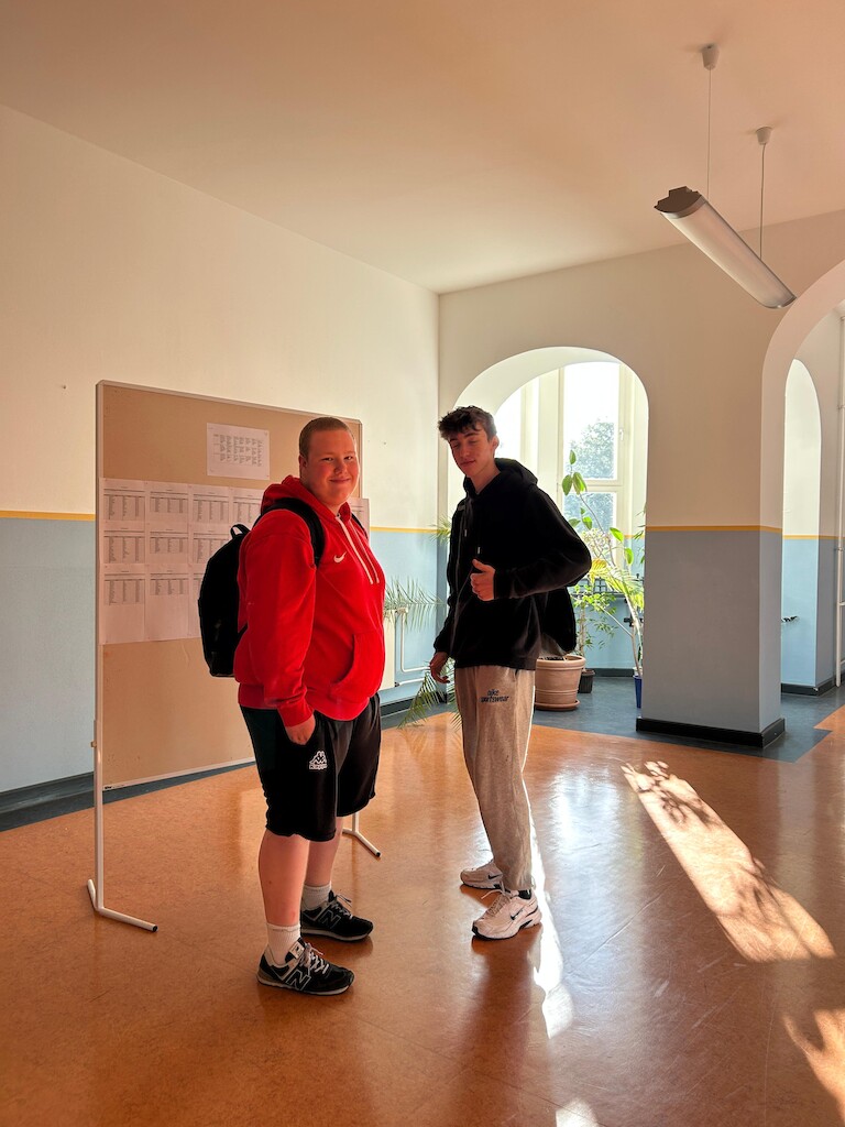 Zwei Schüler mit Daumen hoch vor der Veranstaltungswand
