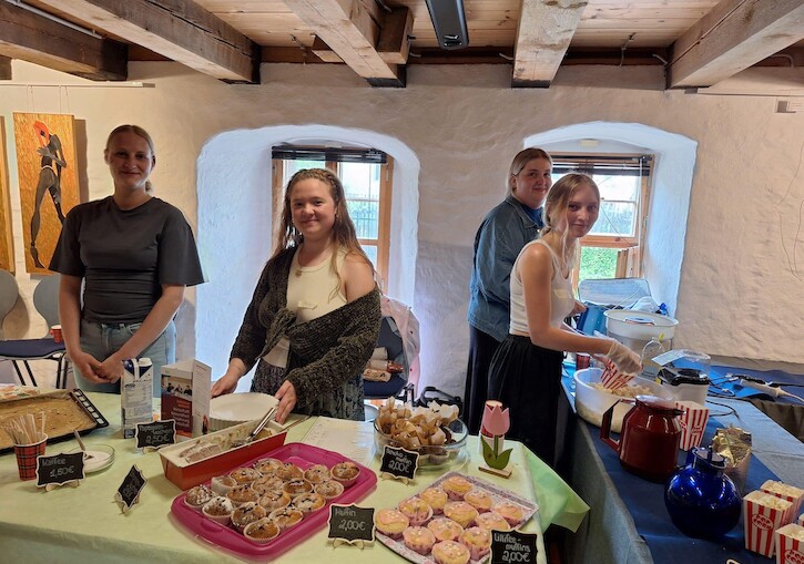 Schülerinnen und Schüler stehen am Kuchenstand