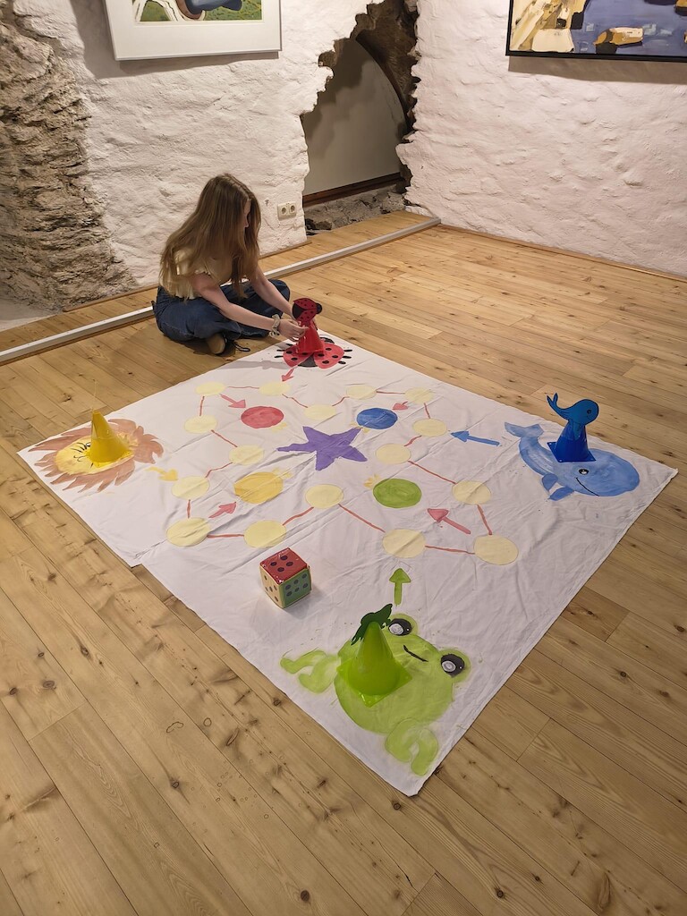ein Kind sitzt am Spielfeld auf dem Boden