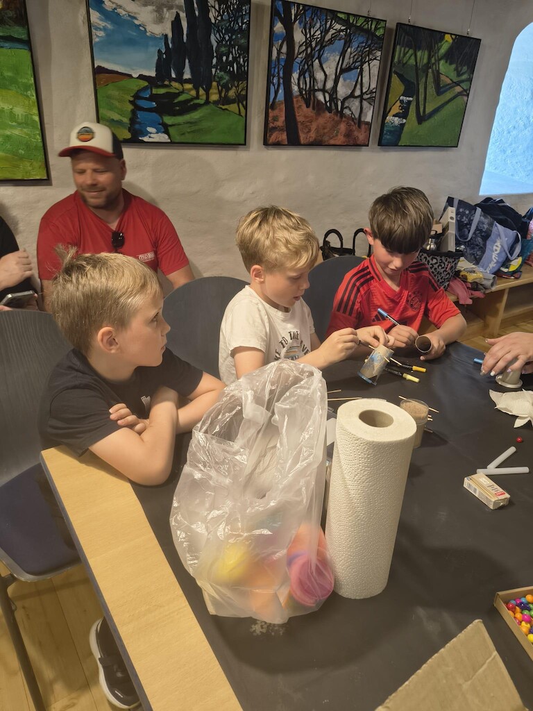 Mehrere Kinder sind kreativ an einer Bastelstation.
