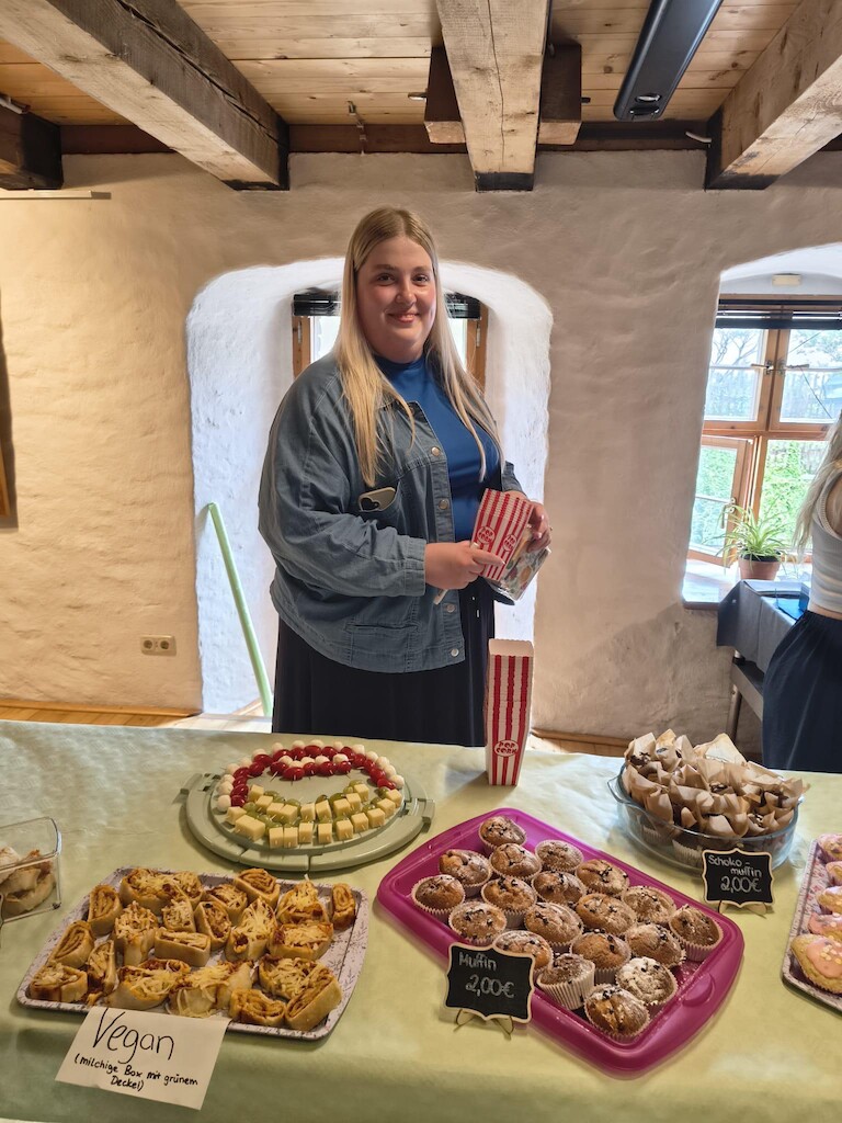 eine Schülerin steht am Kuchenstand