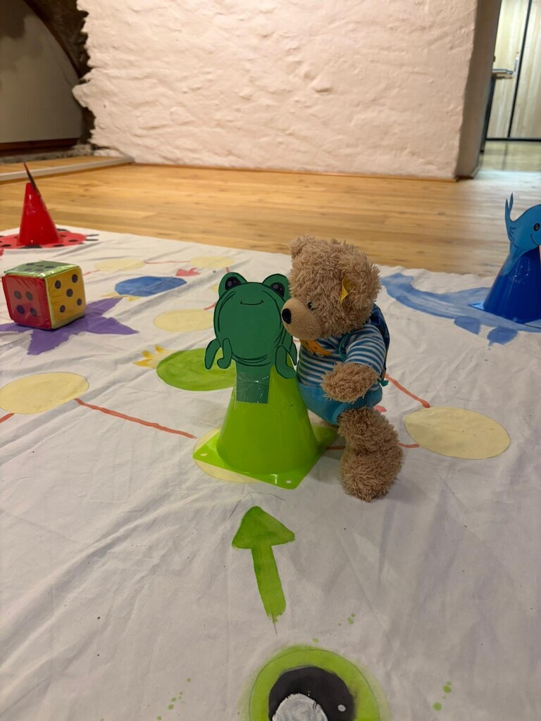 Unser Bär auf dem Spielfeld mit einer Spielfigur.