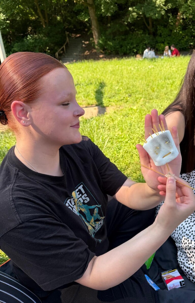 Eine Schüler zeigt ein Gesicht aus Spagetti und Marshmallows